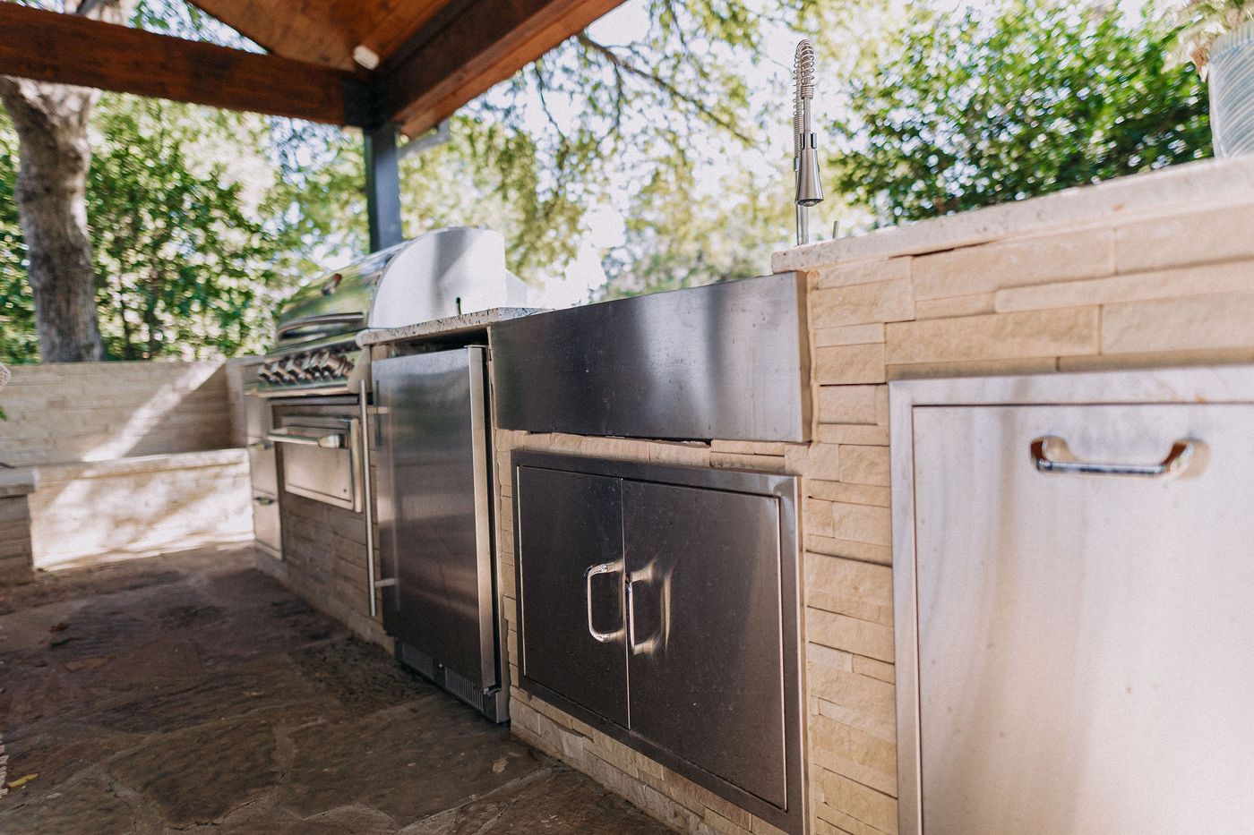 Built-in stainless outdoor kitchen with grill and stone counter