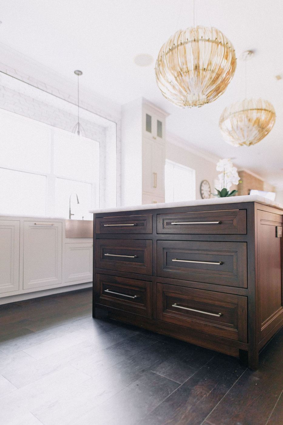 Remodeled kitchen island with brass pendant lighting