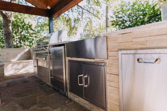Built-in stainless outdoor kitchen with grill and stone counter