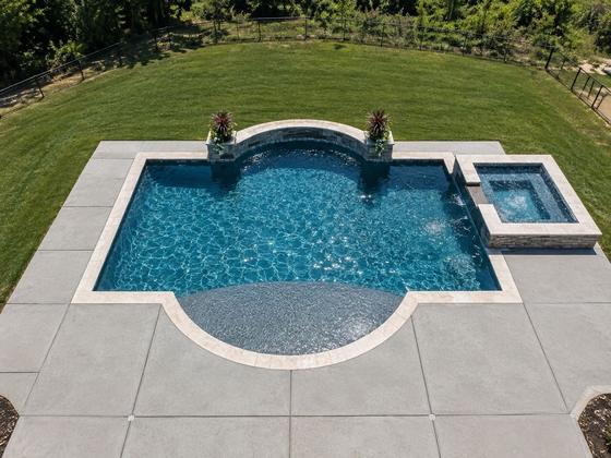 Geometric pool with a raised spa and tanning ledge