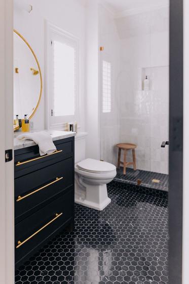 Guest bathroom remodel with black vanity and hex floor tile