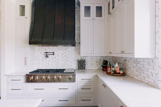 Kitchen remodel with black metal range hood and gas range