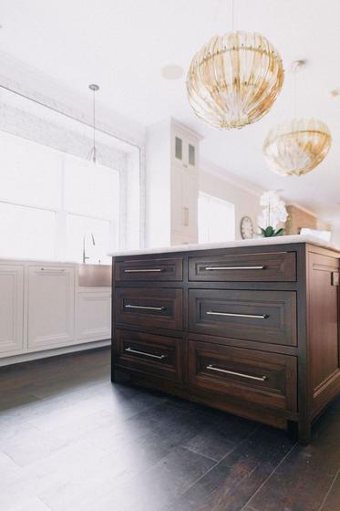 Remodeled kitchen island with brass pendant lighting