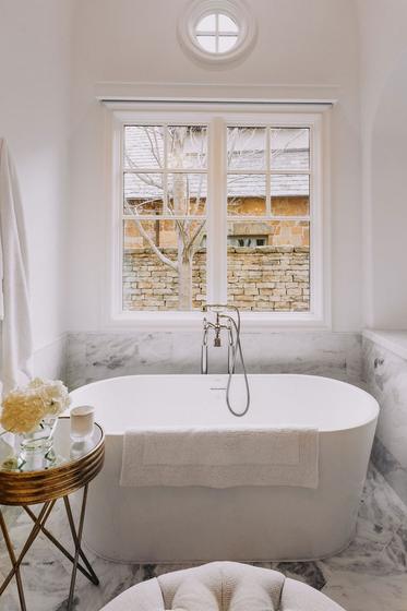 Marble primary bathroom with freestanding tub