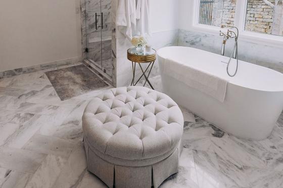 Freestanding soaking tub on marble flooring